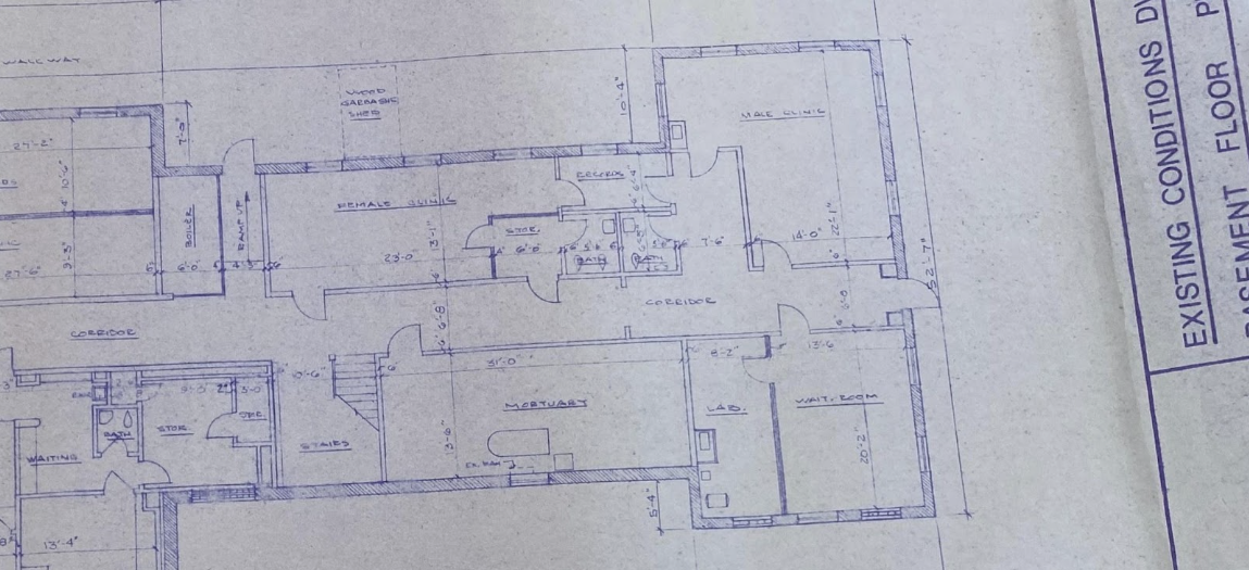 A photo of the blueprint of the basement of Knight Hospital. The paper is textured and off white, and the floor plan is outlined in purple-ish blue ink.]