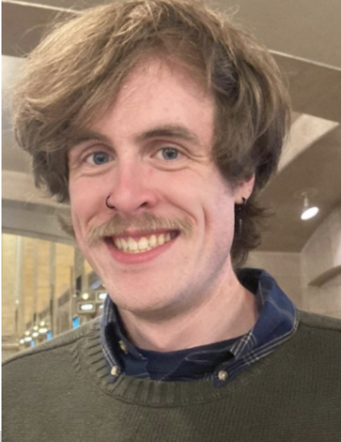 Portrait of Matt Lannantuoni, wearing a green sweater, while smiling